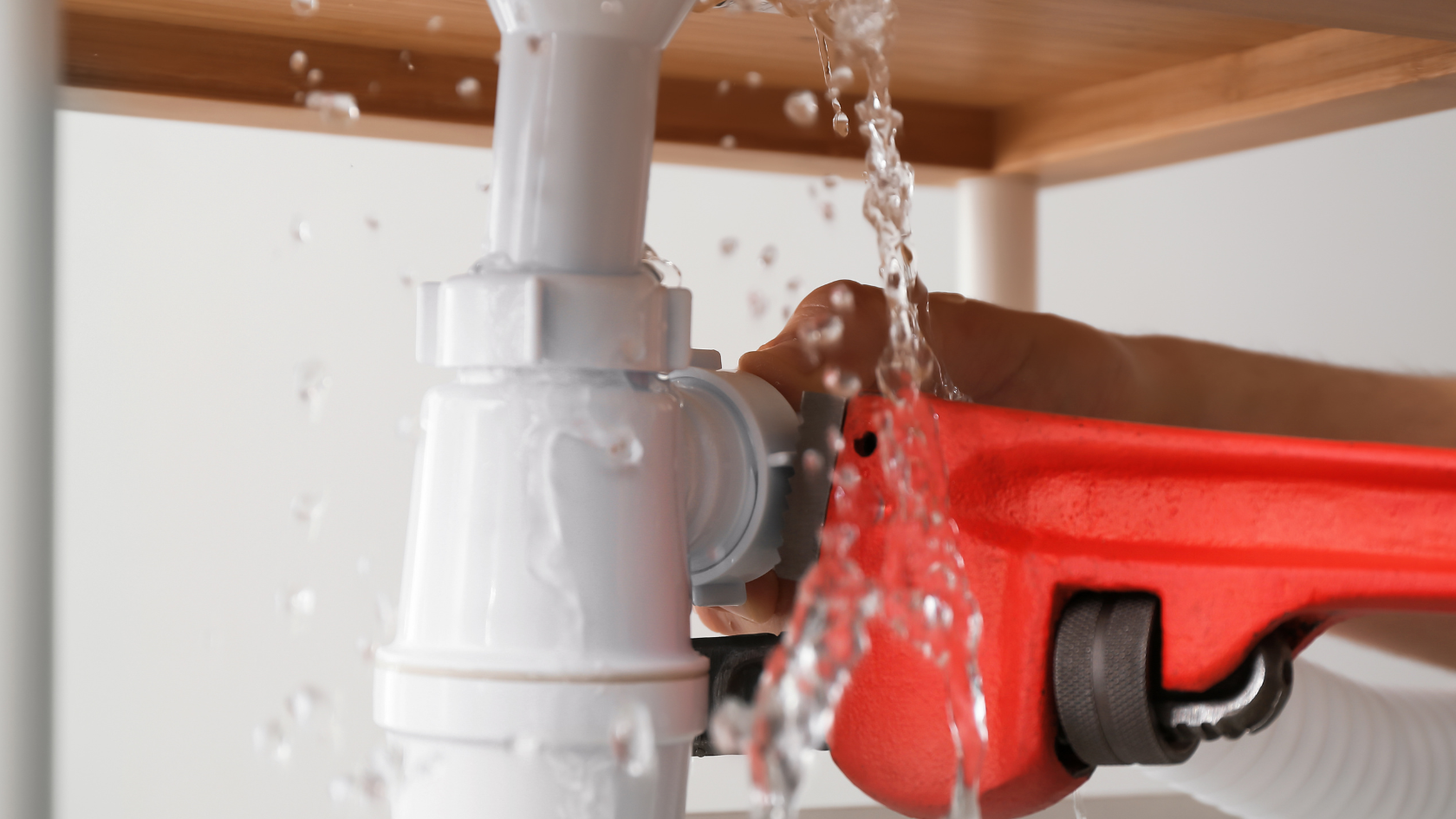 A red and white water hose connected to a pipe