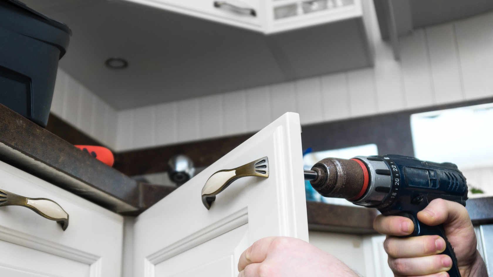 A man is drilling a door with a drill